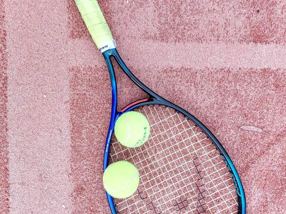 Zwei Tennisschläger und Bälle auf dem Sandplatz