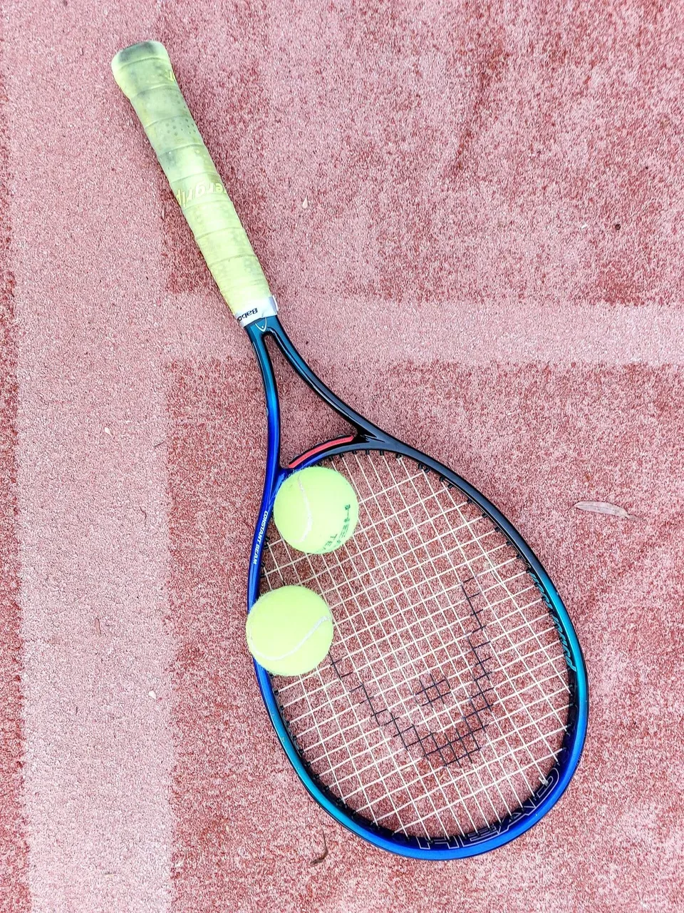 Zwei Tennisschläger und Bälle auf dem Sandplatz
